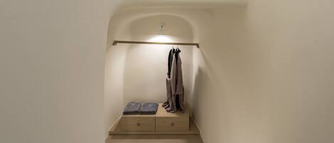 A staircase with a small shelf at the top holding a vase.