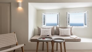 A modern living room with a sofa, two side tables, and a wicker chair.