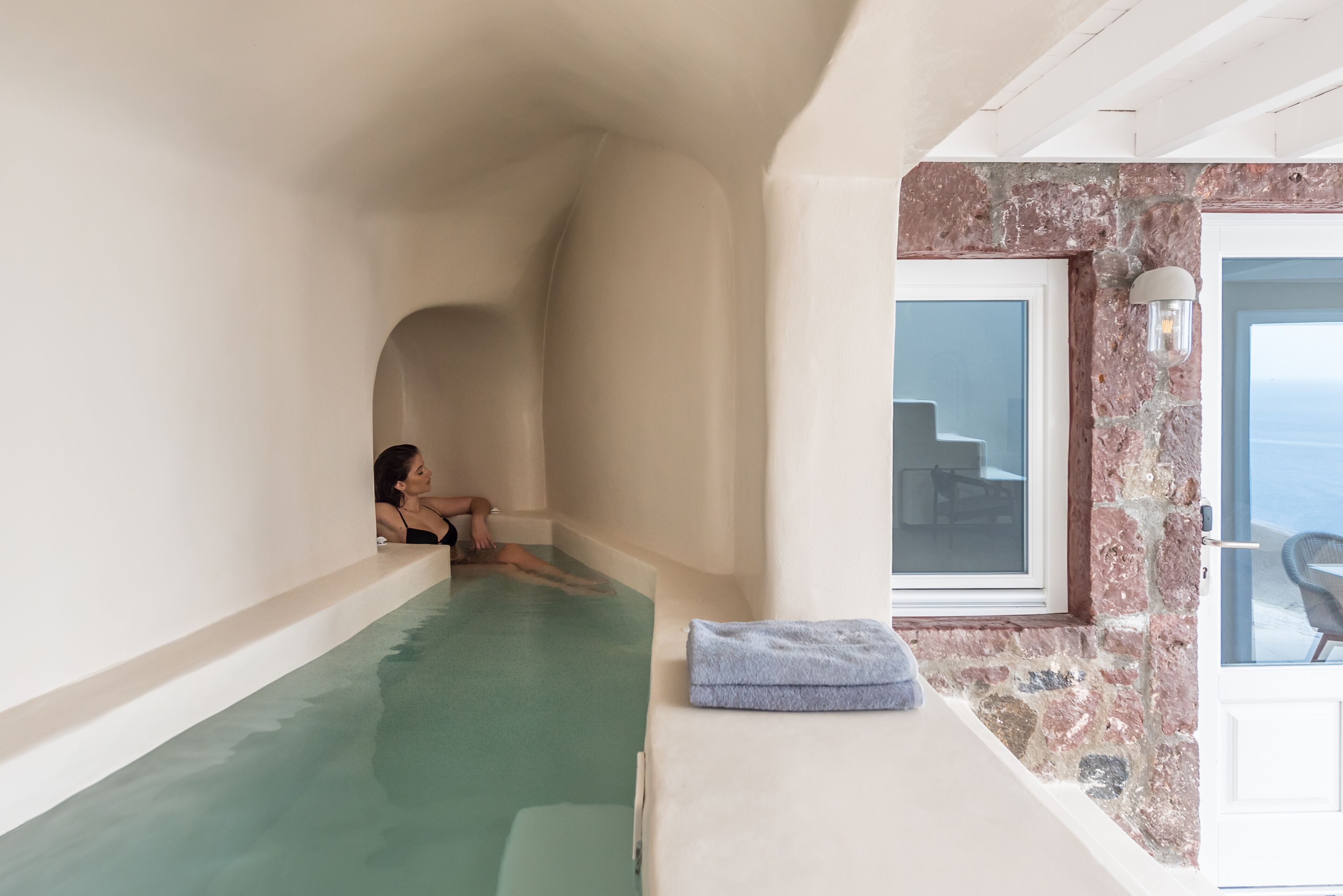 Un cuarto de spa con una bañera, una toalla y una ventana con vistas.