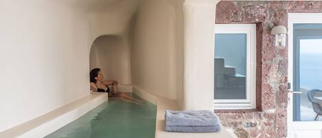 Un cuarto de spa con una bañera, una toalla y una ventana con vistas.
