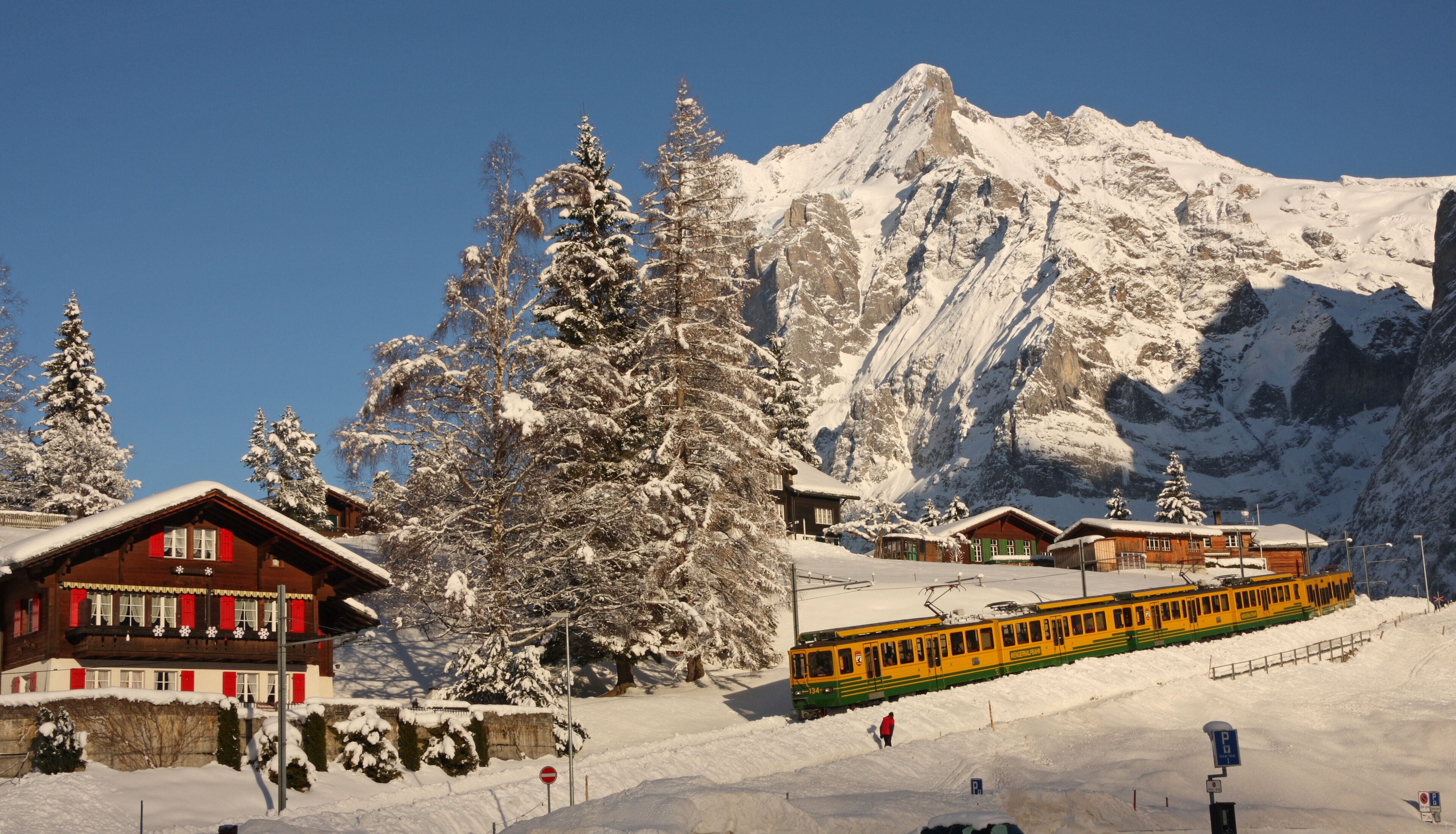 Une montagne enneigée, avec un télésiège et des bâtiments en bois.