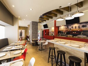 Un restaurante moderno con área de bar, techos altos y una variedad de opciones de asientos, incluidas mesas y taburetes.