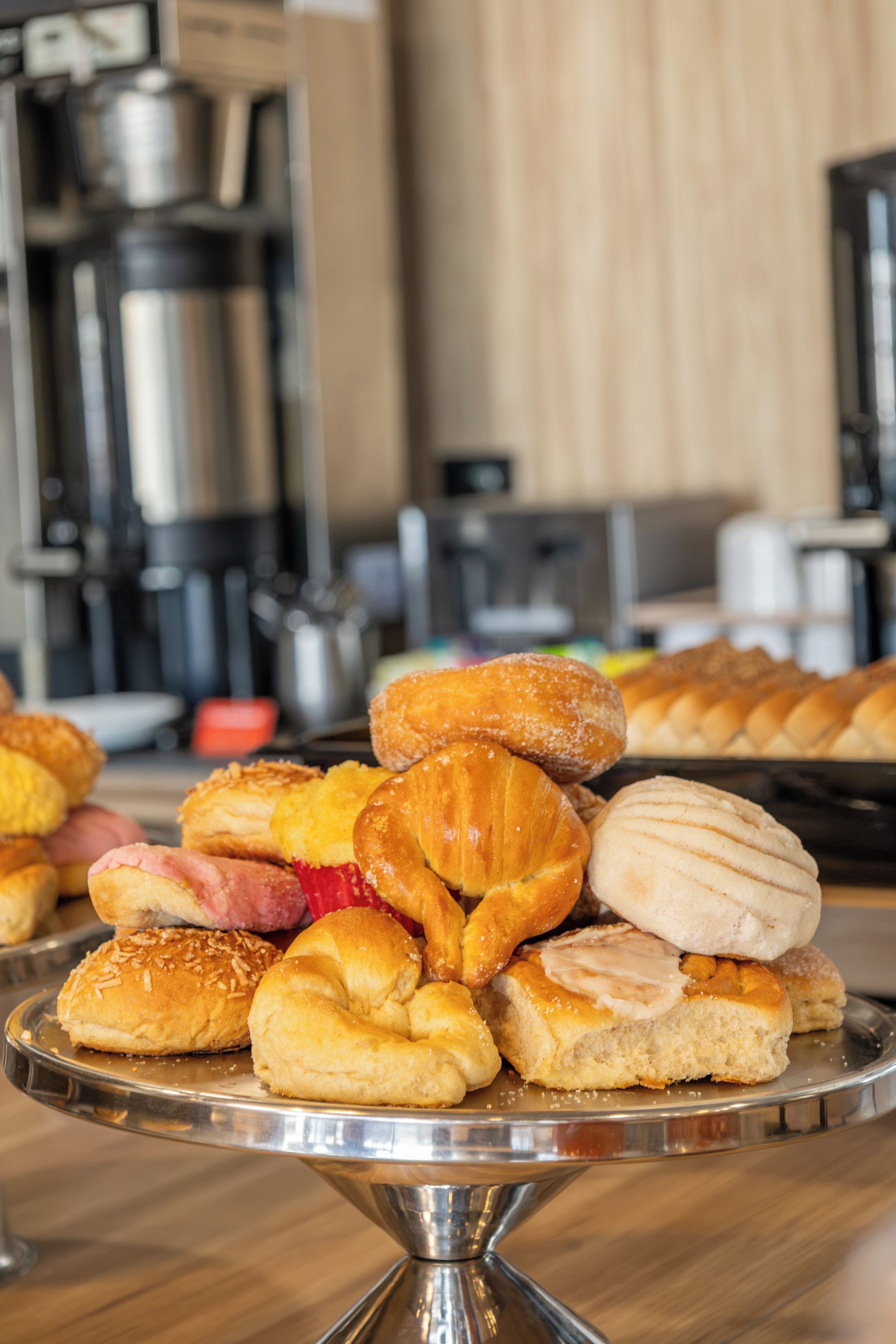 A variety of pastries on a metal stand in a kitchen setting.
