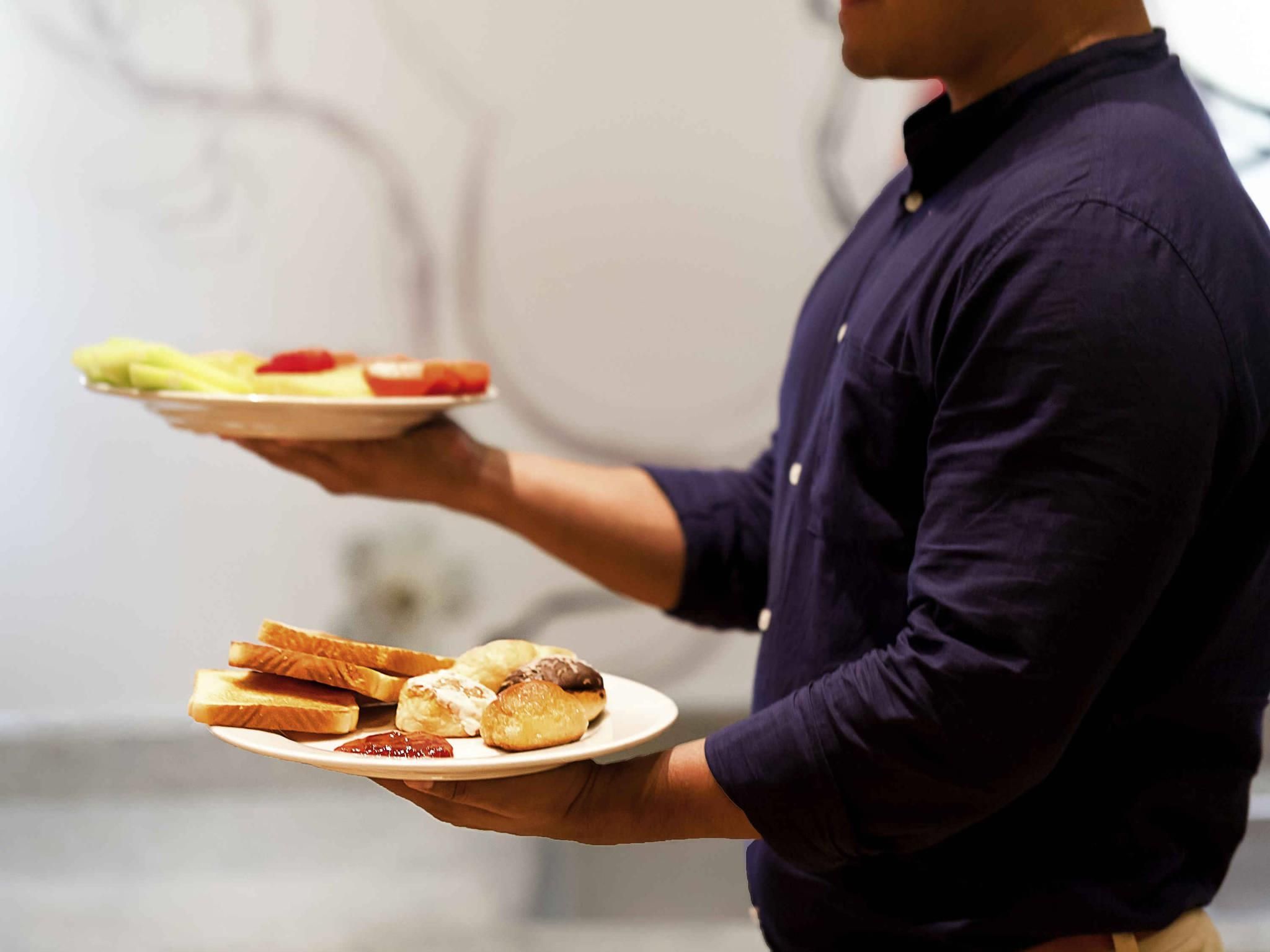 Una persona sosteniendo un plato con comida.