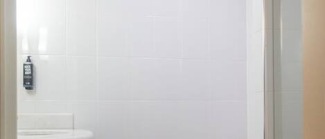 Un baño con inodoro, lavamanos y zona de ducha.
