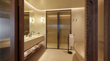 Un baño moderno con cabina de ducha de vidrio, bañera independiente y tocador con espejo y lavabo.