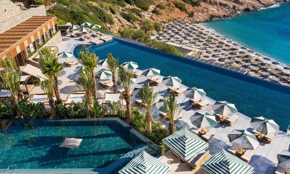 A resort with a large pool, sun loungers, and umbrellas. - Daios Cove (Agios Nikolaos)