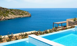 A swimming pool with a view of the sea and a rocky landscape. - Daios Cove (Agios Nikolaos)