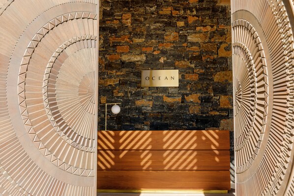 Una escalera de caracol con un cartel que dice "OCEAN" frente a una pared de piedra.