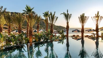 Alberca techada, alberca al aire libre y sombrillas en la alberca