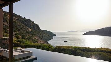Vista de la piscina con vistas al paisaje costero y cielo despejado.