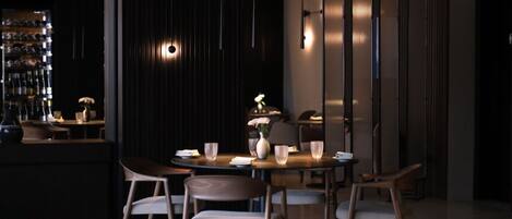 Un coin repas moderne avec une table ronde, six chaises et un vase décoratif.