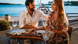 A couple dining at a table with a view of the sea and boats in the background. - Valamar Riviera Hotel & Residence (Porec)