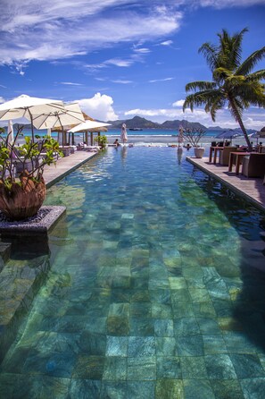 Una piscina al aire libre, sombrillas, tumbonas