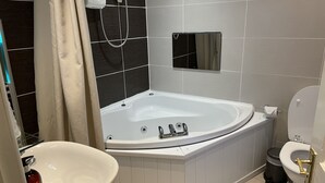 Une salle de bain moderne avec une baignoire sur pieds, un lavabo sur colonne et des toilettes.