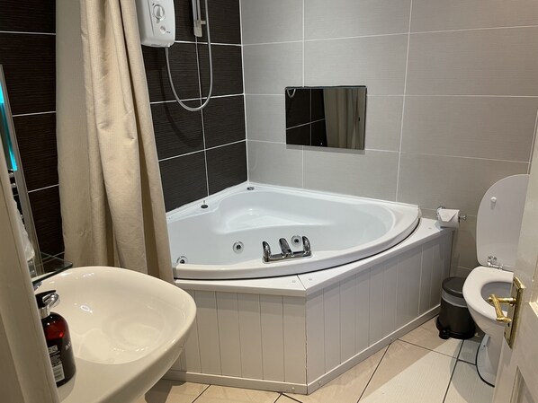 Un baño moderno con una bañera independiente, un lavabo sobre pedestal y un inodoro.