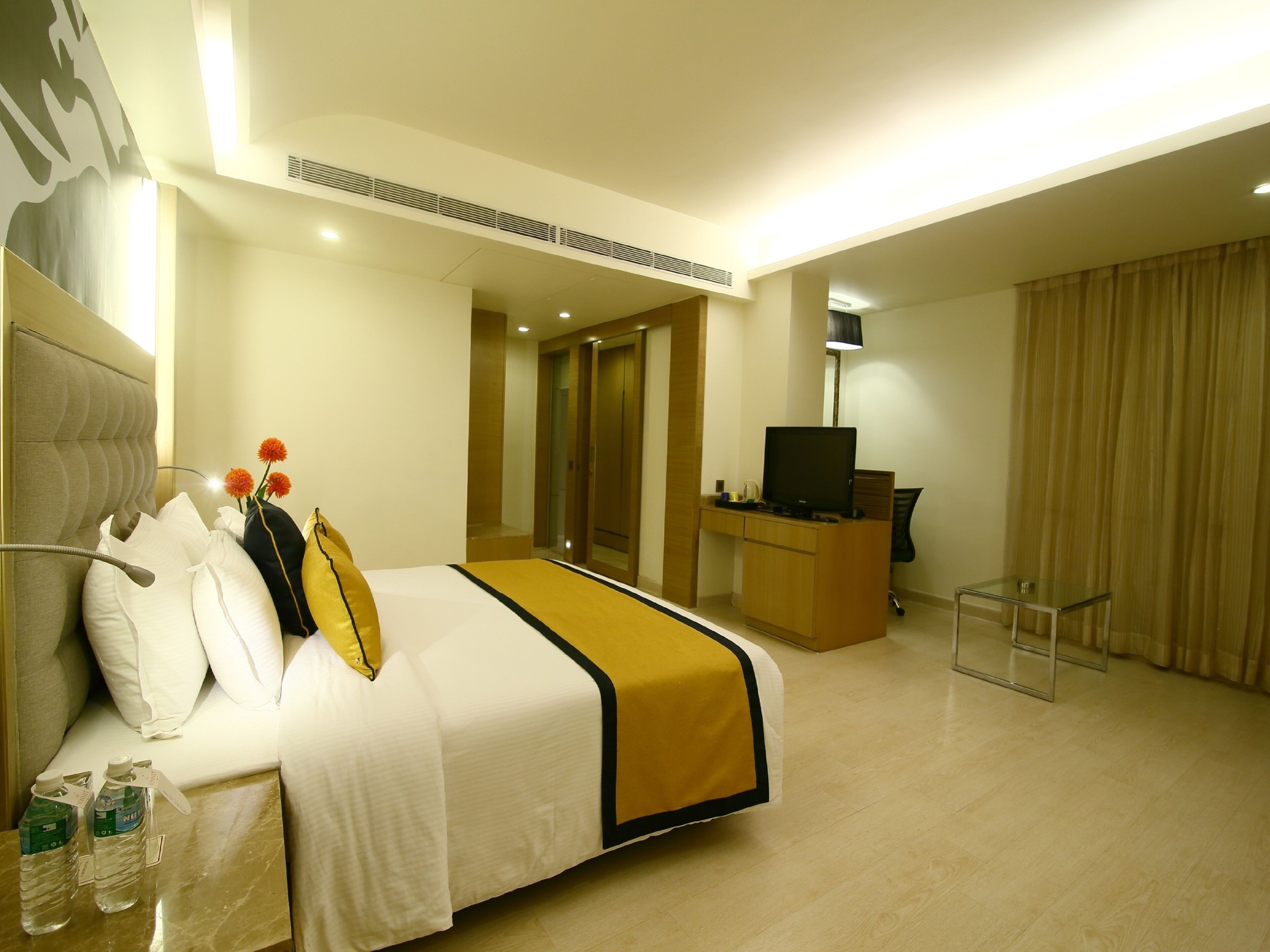 A hotel room with a bed, a desk, a television, and a chair.