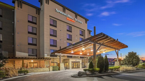 A hotel with a covered entrance, multiple floors, and a sign indicating it is a SpringHill Suites Marriott.