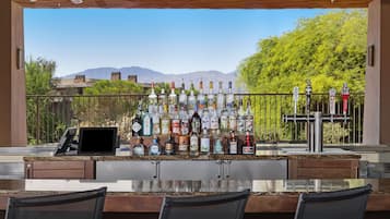 An outdoor bar area with a variety of liquor bottles and a tap bar.