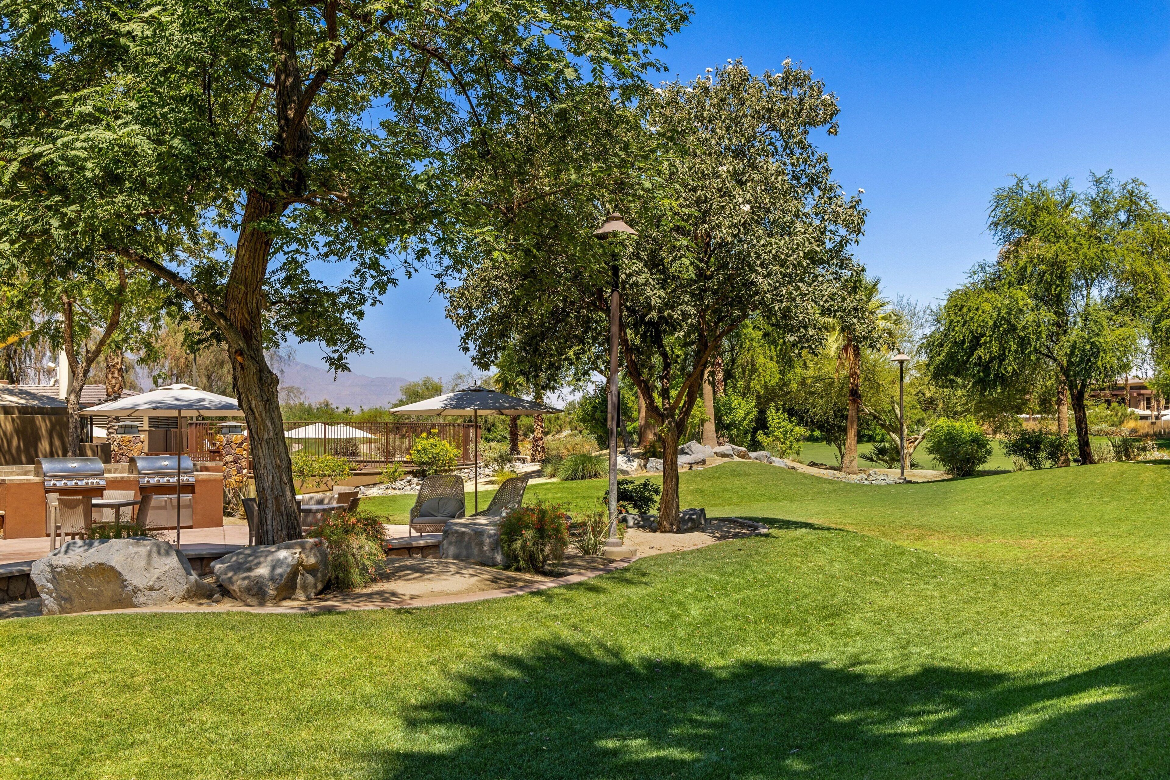 A well-maintained outdoor area with a barbecue setup, seating, and a clear view of the surrounding landscape.