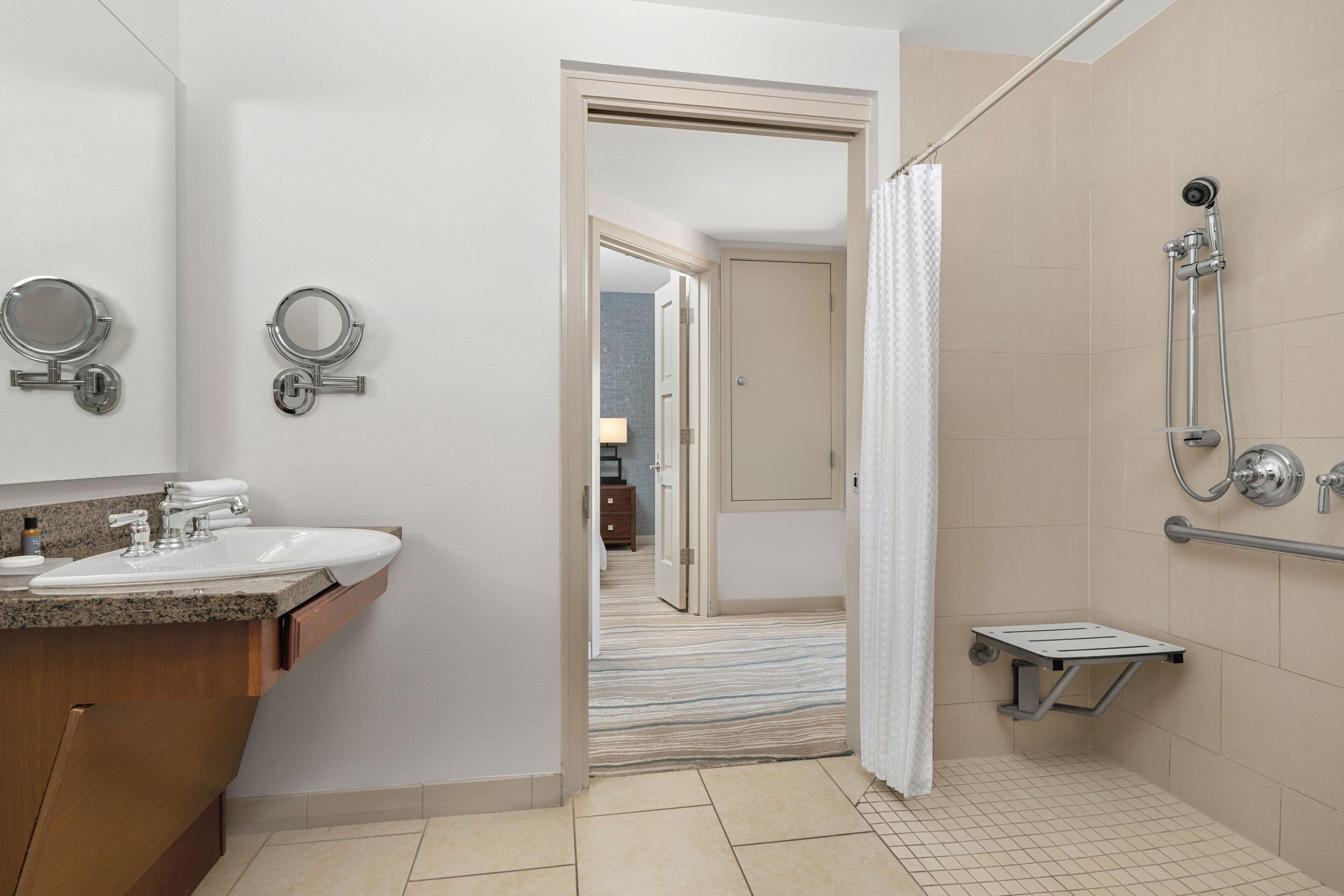 Une salle de bain moderne avec un lavabo, des miroirs et une douche.