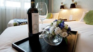 A hotel room with a bed, a bottle of wine, a wine glass, and a tray with flowers. - Central Tourist Hotel (Seoul)