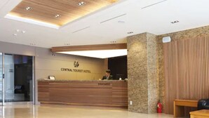 A reception desk with a sign reading "CENTRAL TOURIST HOTEL" and a receptionist. - Central Tourist Hotel (Seoul)