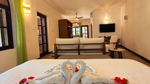 A hotel room with a bed, a television, a desk, and a chair. - Castello Beach Hotel (Praslin Island)