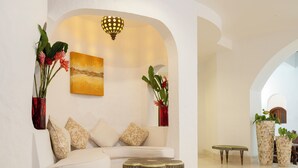 A modern interior with a white sofa, two round tables, and decorative vases. - Village Du Pecheur (Praslin Island)