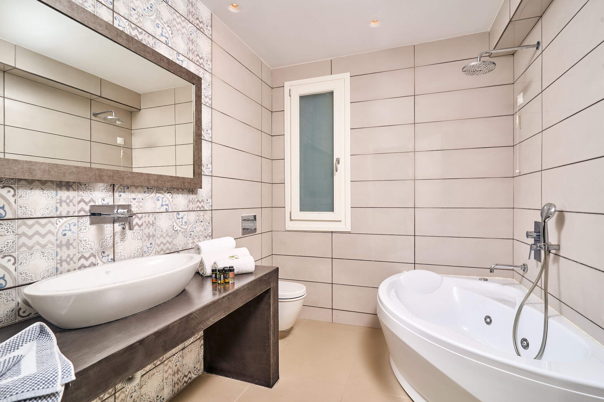 Un baño moderno con lavamanos doble, una bañera grande y una ducha.
