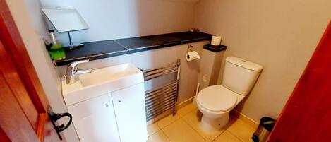 A small bathroom with a toilet, a sink, and a towel rack.