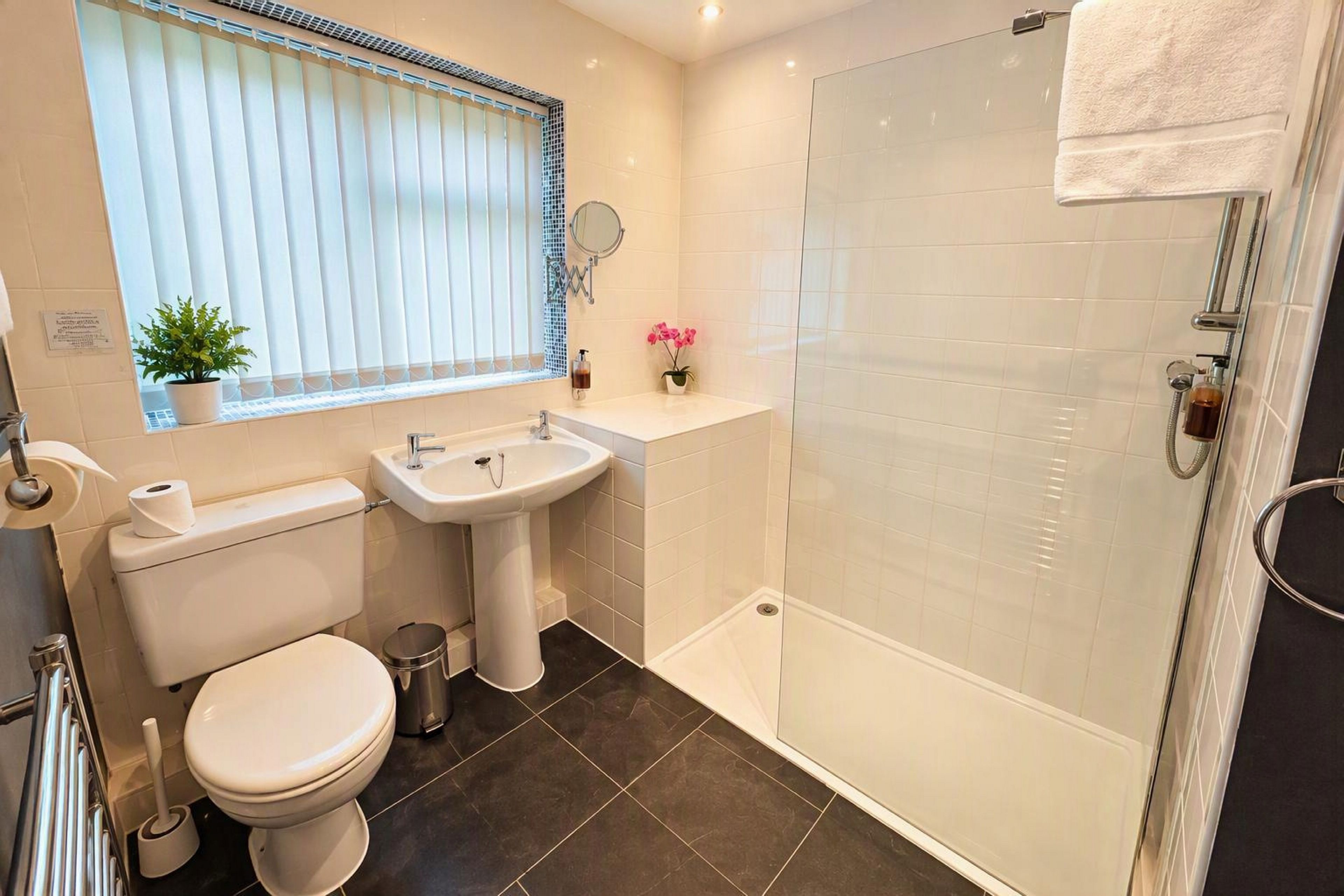Un baño moderno con inodoro, lavabo y ducha.
