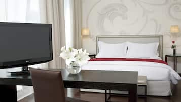 A hotel room with a bed, a TV, a desk, and a chair.