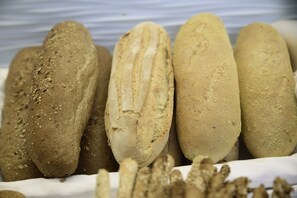 Variedad de panes con semillas sobre una superficie blanca.