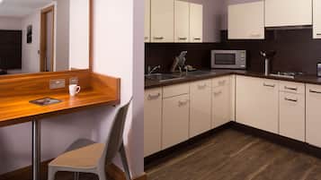 A modern kitchen with wooden countertops, a microwave, and a sink.
