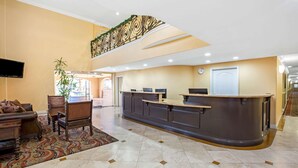 A hotel lobby with a reception desk, seating area, and a staircase. - La Quinta Inn & Suites by Wyndham Moreno Valley (Moreno Valley)
