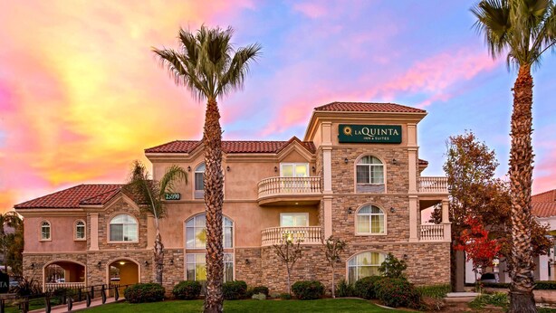 A large, two-story hotel with a stone facade, multiple balconies, and a sign reading "LA QUINTA INN & SUITES." - La Quinta Inn & Suites by Wyndham Moreno Valley (Moreno Valley)