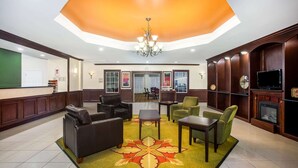 A lobby with a reception desk, seating area with sofas and chairs, a chandelier, and a fireplace. - La Quinta Inn & Suites by Wyndham Columbus TX (Columbus)