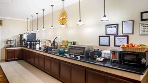 A breakfast bar with a coffee machine, toaster, and microwave. There are hanging lights and a star-shaped decoration on the wall. - La Quinta Inn & Suites by Wyndham Columbus TX (Columbus)