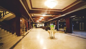 A spacious hotel lobby with a marble floor, a grand staircase, and a chandelier. - Paradise Isle Beach Resort (Udupi)