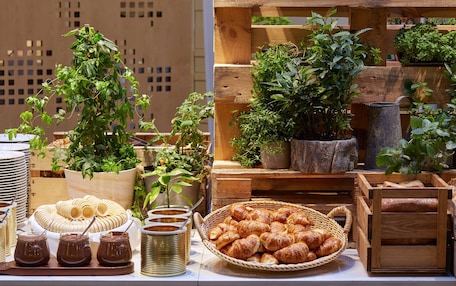 A display of pastries, chocolate, and potted plants on a table.