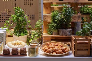 Une table où sont exposés des pâtisseries, des chocolats et des plantes en pot.