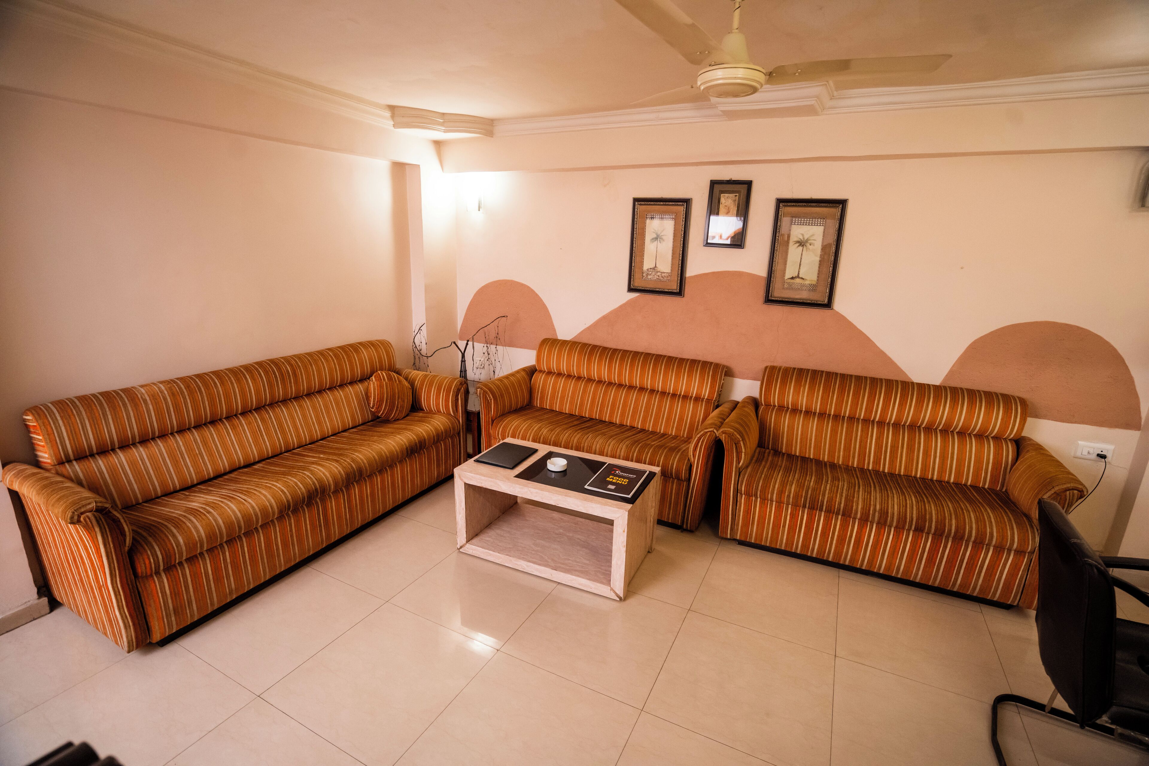 A living room with striped sofas, a coffee table, and wall-mounted artwork.