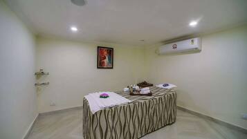 Simple, stylish accommodations with a single bed, table, and air conditioning unit.