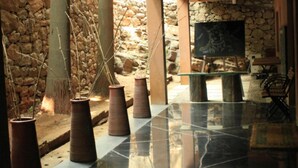 A spacious lobby with stone walls, a large table, and tall vases. - Rainforest Boutique Resort (Chalakudy)