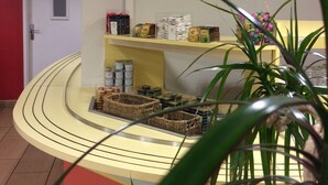 A reception area with a curved counter, a flower painting on the wall, and various items on shelves.