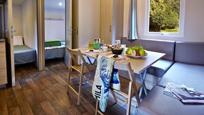Een compacte leefruimte met een kitchenette, een eethoek en een zithoek met uitzicht op de omgeving.