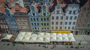 Een rij kleurrijke historische gebouwen met een grote witte tentstructuur op de voorgrond.
