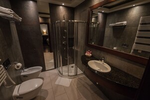 A modern bathroom with a glass-enclosed shower, a sink, and a toilet.
