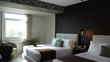 Habitación de hotel con dos camas, un escritorio, una silla, un ventanal y una pared con líneas verticales.